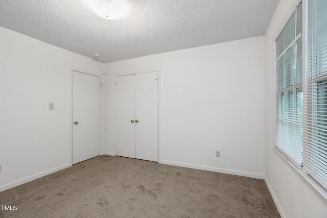 1809-1811 Quail Ridge Rd, Raleigh, NC 27609 - unfurnished bedroom featuring carpet floors, a closet, baseboards, and a textured ceiling