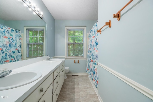 1809-1811 Quail Ridge Rd, Raleigh, NC 27609 - bathroom featuring toilet, double vanity, a textured ceiling, baseboards, and a shower with shower curtain