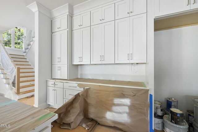 1229 Dixie Trl, Raleigh, NC 27607 - kitchen featuring white cabinetry, crown molding, and light countertops