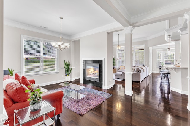 1808 Pennypacker Ln, Durham, NC 27703 - living area featuring dark wood-type flooring, ornate columns, a tiled fireplace, baseboards, and crown molding