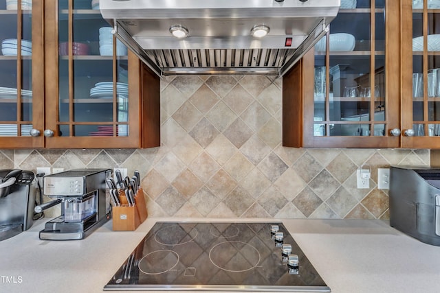 1808 Pennypacker Ln, Durham, NC 27703 - kitchen featuring extractor fan, black electric stovetop, glass insert cabinets, light countertops, and backsplash