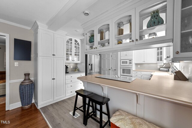 5412 Farley Dr, Raleigh, NC 27609 - kitchen with white appliances, ornamental molding, dark wood-style flooring, a peninsula, and light countertops