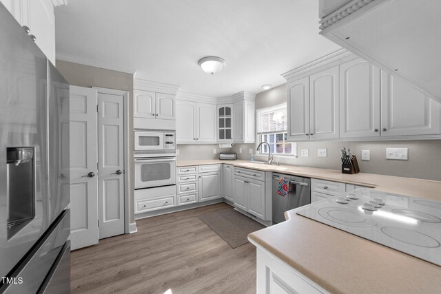 5412 Farley Dr, Raleigh, NC 27609 - kitchen with stainless steel appliances, white cabinets, light wood-style flooring, and light countertops