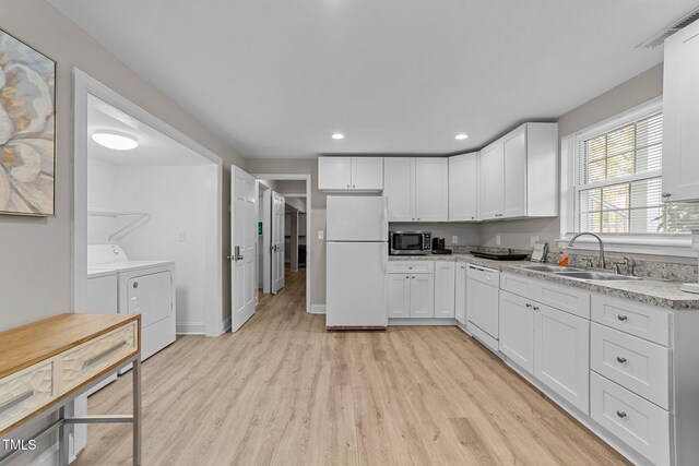 5412 Farley Dr, Raleigh, NC 27609 - kitchen featuring white appliances, separate washer and dryer, light wood-style floors, white cabinets, and recessed lighting