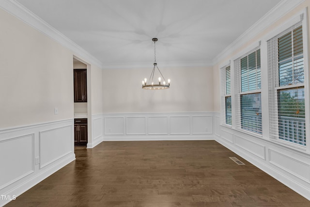 216 Pondside Dr, Apex, NC 27539 - unfurnished dining area featuring a chandelier, crown molding, dark wood finished floors, wainscoting, and a decorative wall
