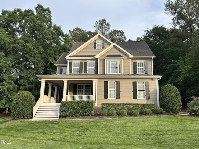 126 Riverglade Dr, Clayton, NC 27527 - view of front of house featuring covered porch, stairs, a front lawn, a standing seam roof, and a shingled roof