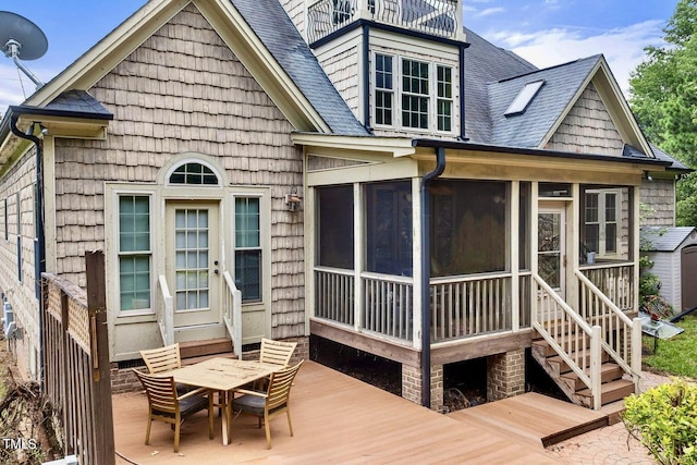 4720 Yates Mill Pond Rd, Raleigh, NC 27606 - back of property featuring a shingled roof, a sunroom, a wooden deck, and outdoor dining space