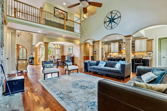 4720 Yates Mill Pond Rd, Raleigh, NC 27606 - living area featuring decorative columns, a high ceiling, ceiling fan, a chandelier, and crown molding
