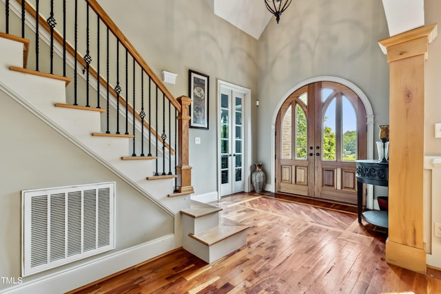 4720 Yates Mill Pond Rd, Raleigh, NC 27606 - foyer featuring french doors, wood-type flooring, a towering ceiling, stairway, and baseboards