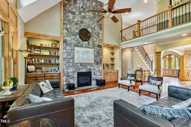 4720 Yates Mill Pond Rd, Raleigh, NC 27606 - living area with high vaulted ceiling, ceiling fan, stairs, a fireplace, and arched walkways