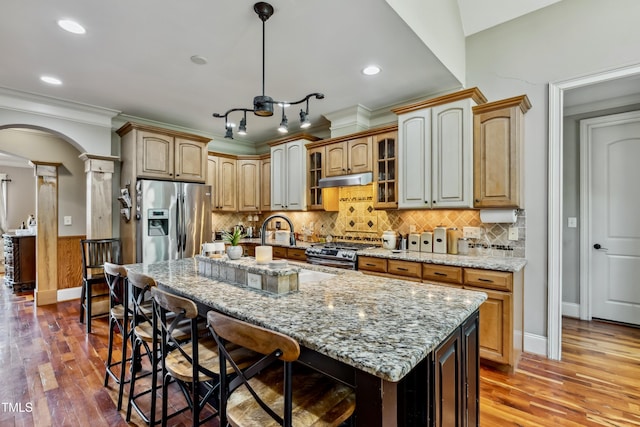 4720 Yates Mill Pond Rd, Raleigh, NC 27606 - kitchen with stainless steel appliances, decorative columns, arched walkways, a breakfast bar area, and ornamental molding