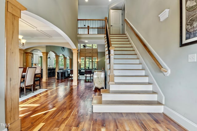 4720 Yates Mill Pond Rd, Raleigh, NC 27606 - stairway featuring a high ceiling, ornate columns, wood finished floors, arched walkways, and baseboards