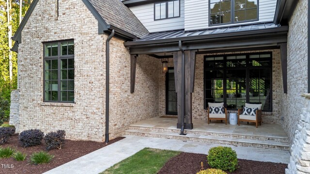 15517 Possum Track Rd, Raleigh, NC 27614 - view of exterior entry with a standing seam roof, covered porch, brick siding, and metal roof