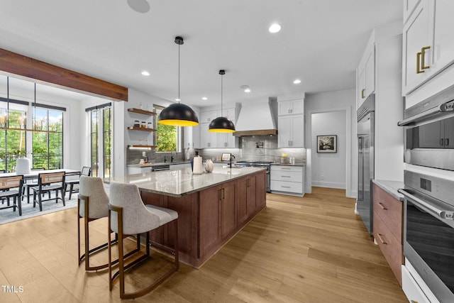 15517 Possum Track Rd, Raleigh, NC 27614 - kitchen featuring custom exhaust hood, backsplash, light wood-style floors, recessed lighting, and a sink