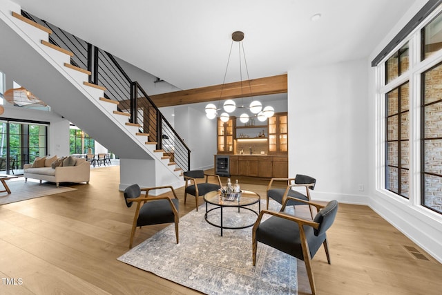 15517 Possum Track Rd, Raleigh, NC 27614 - living area with stairway, wood finished floors, beverage cooler, baseboards, and a chandelier