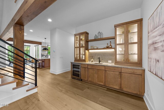 15517 Possum Track Rd, Raleigh, NC 27614 - indoor wet bar featuring wine cooler, light wood-type flooring, tasteful backsplash, stairs, and recessed lighting
