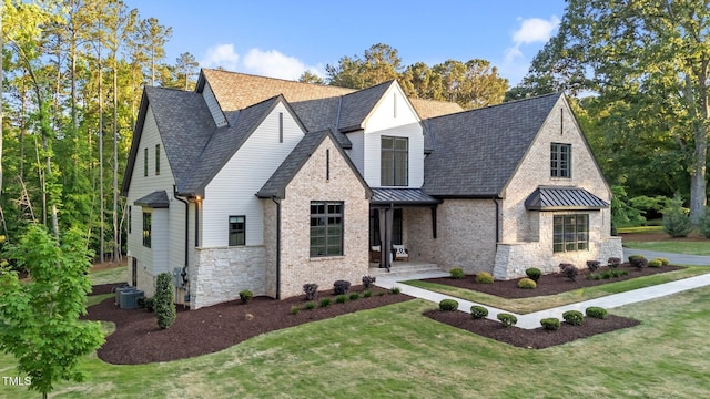 15517 Possum Track Rd, Raleigh, NC 27614 - view of front of house featuring a standing seam roof, stone siding, a front yard, and a shingled roof