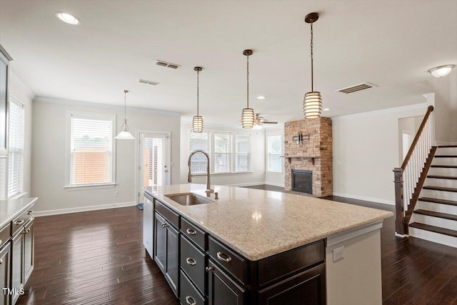 125 Durban Meadow Dr, Holly Springs, NC 27540 - kitchen featuring a sink, baseboards, dark wood-style floors, a ceiling fan, and a fireplace
