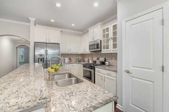 43 Salt Cedar Ln, Chapel Hill, NC 27516 - kitchen with appliances with stainless steel finishes, a sink, white cabinetry, crown molding, and arched walkways