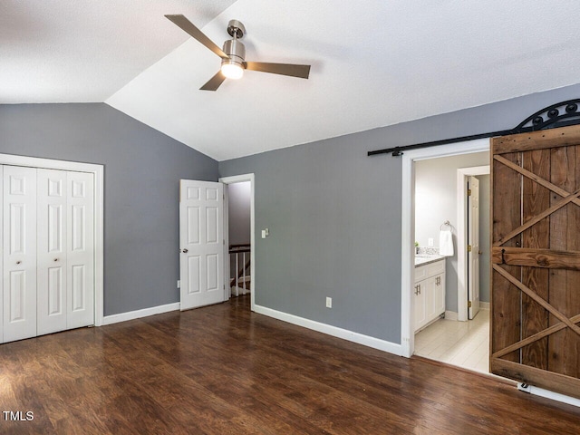 102 Sanair Ct, Apex, NC 27502 - unfurnished bedroom with a barn door, wood finished floors, lofted ceiling, a closet, and baseboards