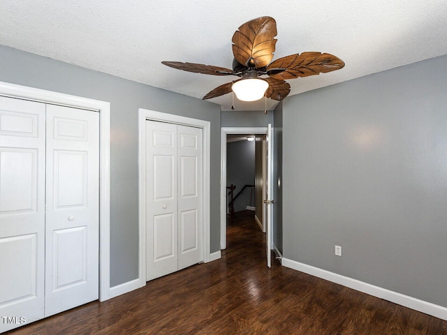102 Sanair Ct, Apex, NC 27502 - unfurnished bedroom featuring multiple closets, baseboards, wood finished floors, and ceiling fan