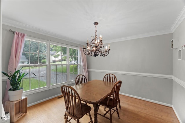 2750 Michelle Ct, Creedmoor, NC 27522 - dining room featuring healthy amount of natural light, a chandelier, wood finished floors, and ornamental molding