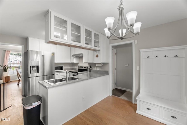 2750 Michelle Ct, Creedmoor, NC 27522 - kitchen with stainless steel appliances, under cabinet range hood, a chandelier, glass insert cabinets, and white cabinetry