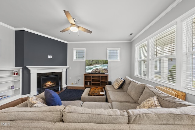 6313 Kayton St, Raleigh, NC 27616 - living area featuring a ceiling fan, wood finished floors, a warm lit fireplace, healthy amount of natural light, and ornamental molding
