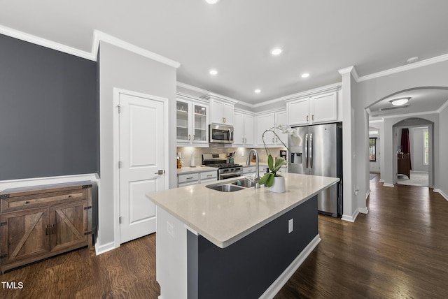 6313 Kayton St, Raleigh, NC 27616 - kitchen featuring appliances with stainless steel finishes, arched walkways, dark wood-type flooring, a sink, and white cabinetry