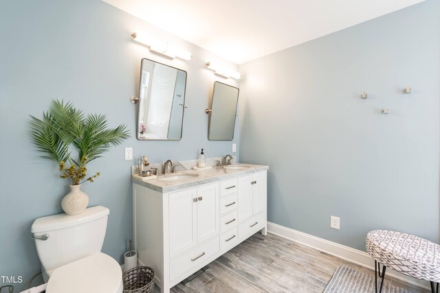 11217 Maplecroft Ct, Raleigh, NC 27617 - bathroom with double vanity, wood finished floors, toilet, and baseboards