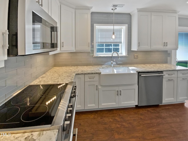 117 Brierridge Dr, Apex, NC 27502 - kitchen with appliances with stainless steel finishes, a sink, decorative backsplash, white cabinetry, and light stone counters