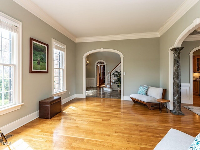5768 Cavanaugh Dr, Raleigh, NC 27614 - living area with arched walkways, ornate columns, ornamental molding, light wood-type flooring, and stairway