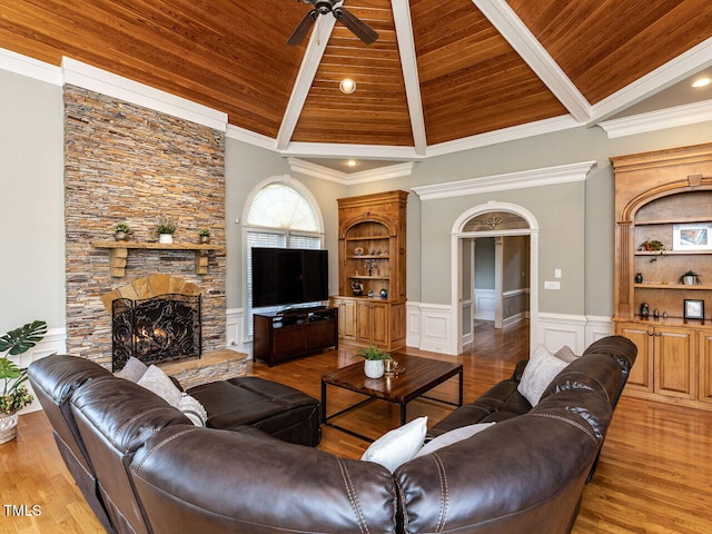 5768 Cavanaugh Dr, Raleigh, NC 27614 - living area featuring a wooden ceiling with exposed beams, a ceiling fan, a fireplace, light wood finished floors, and wainscoting