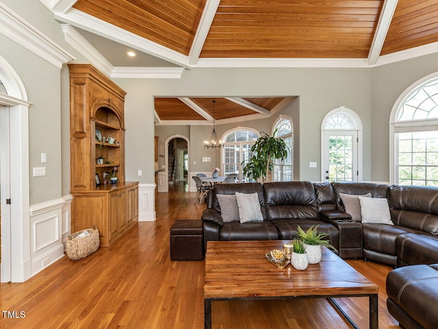 5768 Cavanaugh Dr, Raleigh, NC 27614 - living area featuring a wooden ceiling with exposed beams, wood finished floors, arched walkways, crown molding, and a chandelier