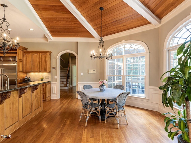 5768 Cavanaugh Dr, Raleigh, NC 27614 - dining space featuring a chandelier, arched walkways, wood ceiling, stairway, and healthy amount of natural light