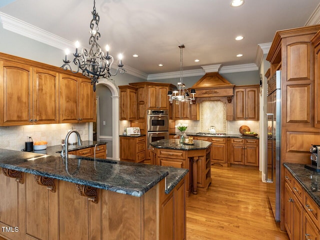 5768 Cavanaugh Dr, Raleigh, NC 27614 - kitchen featuring appliances with stainless steel finishes, a chandelier, brown cabinets, custom range hood, and a peninsula