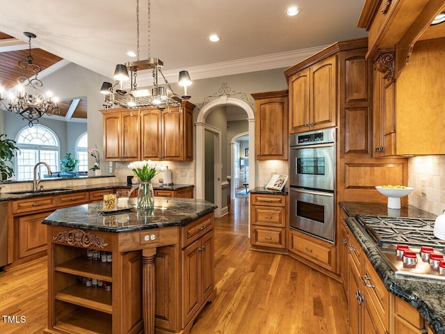 5768 Cavanaugh Dr, Raleigh, NC 27614 - kitchen with appliances with stainless steel finishes, crown molding, brown cabinetry, light wood-style floors, and decorative backsplash