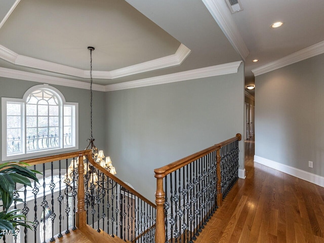 5768 Cavanaugh Dr, Raleigh, NC 27614 - hallway with an upstairs landing, wood finished floors, recessed lighting, ornamental molding, and a tray ceiling