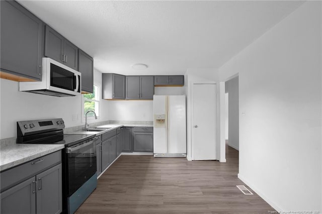 4709 Alamance Rd, Fayetteville, NC 28304 - kitchen featuring white appliances, a sink, gray cabinetry, and dark wood finished floors