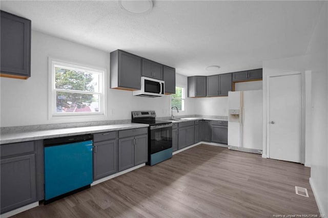 4709 Alamance Rd, Fayetteville, NC 28304 - kitchen featuring white appliances, a sink, gray cabinets, dark wood-type flooring, and a textured ceiling