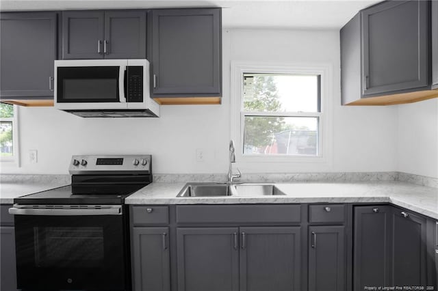 4709 Alamance Rd, Fayetteville, NC 28304 - kitchen with stainless steel electric range, a sink, gray cabinetry, and plenty of natural light
