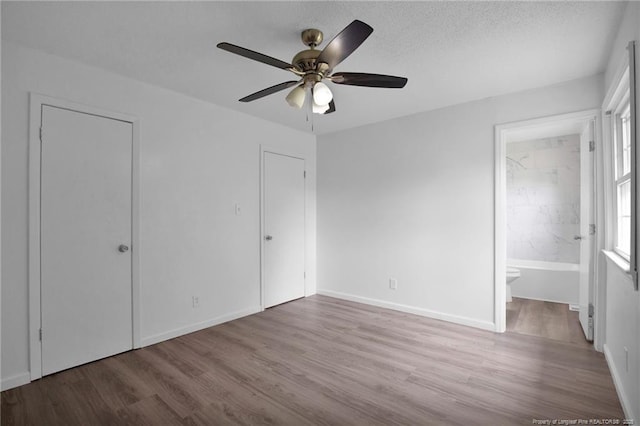 4709 Alamance Rd, Fayetteville, NC 28304 - unfurnished bedroom with wood finished floors, baseboards, ensuite bathroom, and a ceiling fan