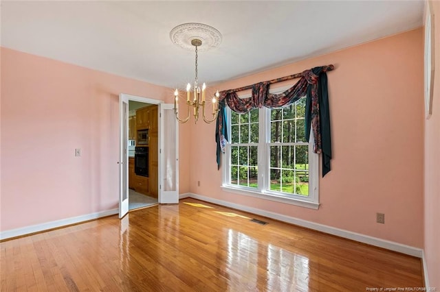 1718 Carthage St, Sanford, NC 27330 - unfurnished dining area featuring a chandelier, baseboards, and wood finished floors