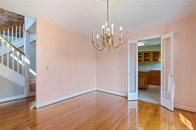 1718 Carthage St, Sanford, NC 27330 - unfurnished dining area with light wood finished floors, a chandelier, stairs, and baseboards