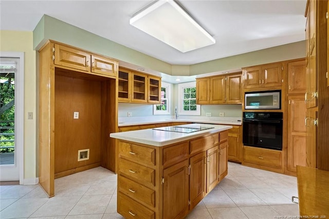 1718 Carthage St, Sanford, NC 27330 - kitchen featuring black appliances, light countertops, a kitchen island, and light tile patterned flooring