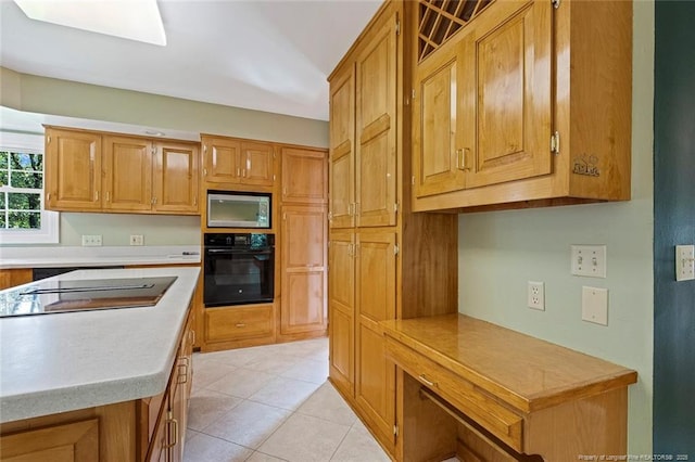 1718 Carthage St, Sanford, NC 27330 - kitchen featuring black oven, light countertops, stainless steel microwave, and brown cabinetry