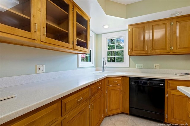 1718 Carthage St, Sanford, NC 27330 - kitchen featuring dishwasher, a sink, brown cabinetry, light countertops, and glass insert cabinets