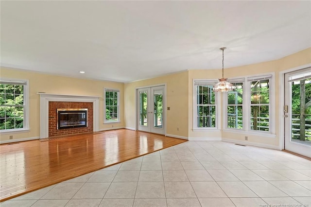 1718 Carthage St, Sanford, NC 27330 - unfurnished living room featuring light tile patterned floors, a chandelier, baseboards, and a fireplace