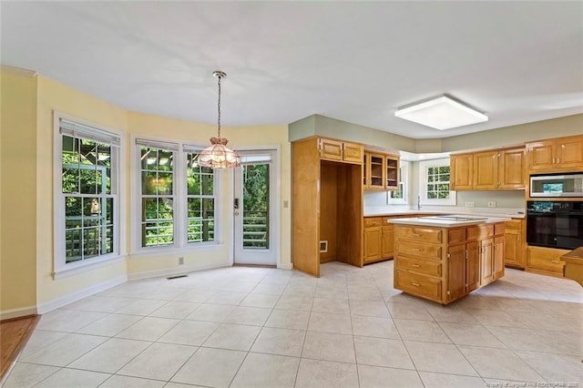 1718 Carthage St, Sanford, NC 27330 - kitchen featuring oven, a chandelier, stainless steel microwave, light countertops, and baseboards
