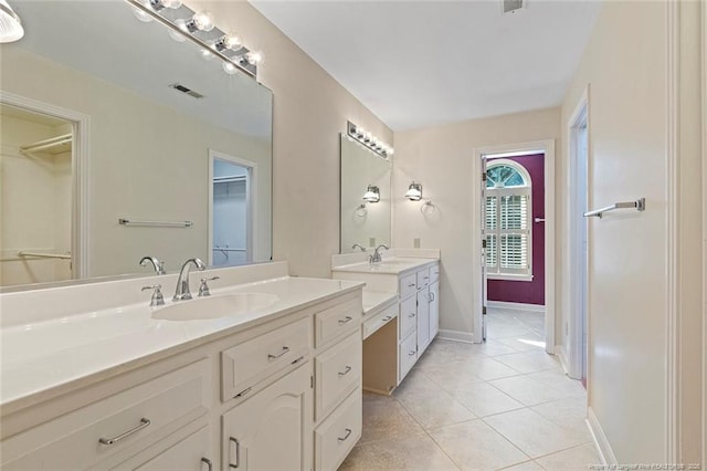 1718 Carthage St, Sanford, NC 27330 - bathroom with two vanities, tile patterned floors, baseboards, and a walk in closet